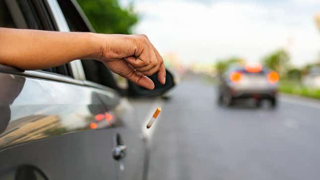 Young man smoking a cigarette in car.