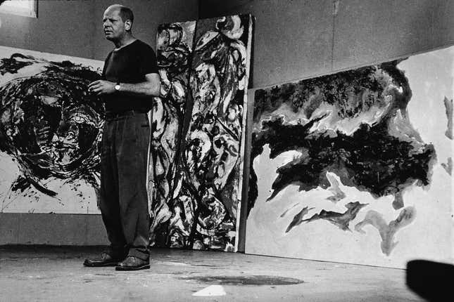 Der amerikanische abstrakte Expressionist Jackson Pollock (1912–1956) steht inmitten einiger großer Gemälde in seinem Atelier in „The Springs“, East Hampton, New York, 23. August 1953. Nummer 17A nicht abgebildet.