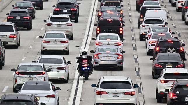 A motorcycle officer weaves through traffic on a Los Angeles freeway during the evening rush hour on April 12, 2023 in Los Angeles, California.