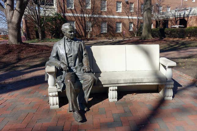 Statue of William Peace sitting on a bench on the college campus named after him.