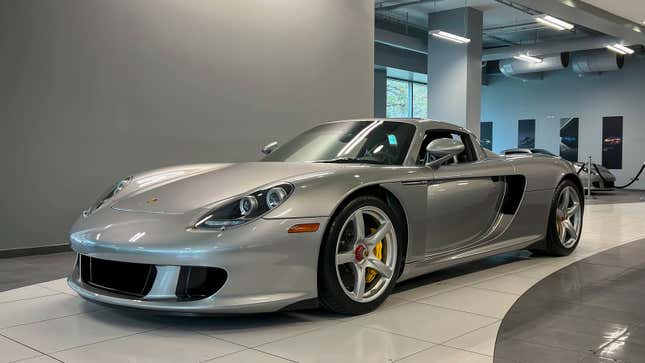 A silver Porsche Carrera GT in a car dealer