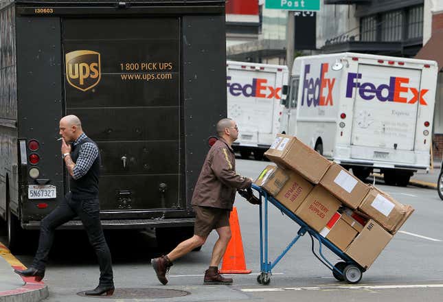 UPS driver Grant Jung (R) pushes a handtruck loaded with boxes as he makes deliveries in San Francisco, California. 