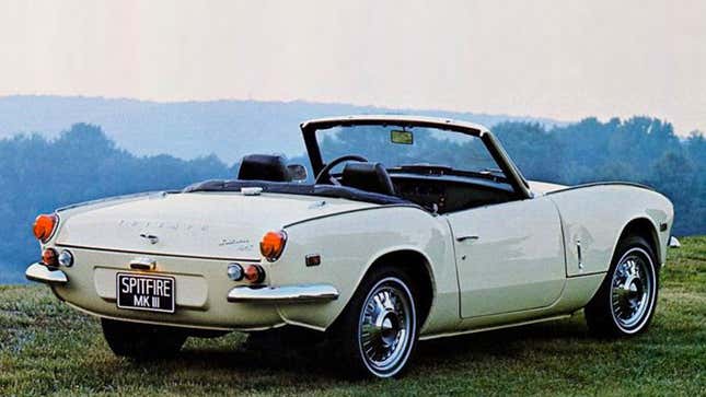 A photo of a vintage Triumph Spitfire convertible car that is painted white. 