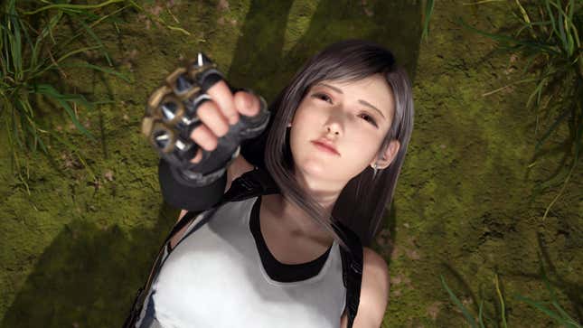 Tifa holds her fist up to the air while laying on the ground.