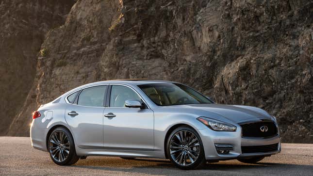 A silver Infiniti Q70 parked in front of a cliff