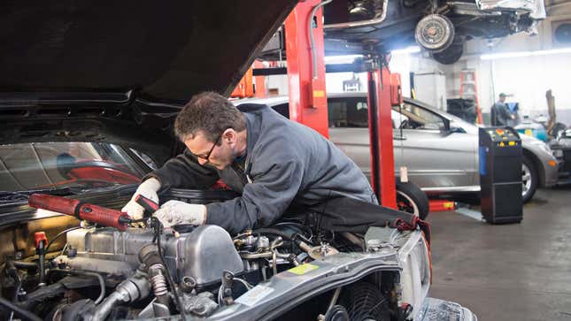 A mechanic working on a car inside of a garage