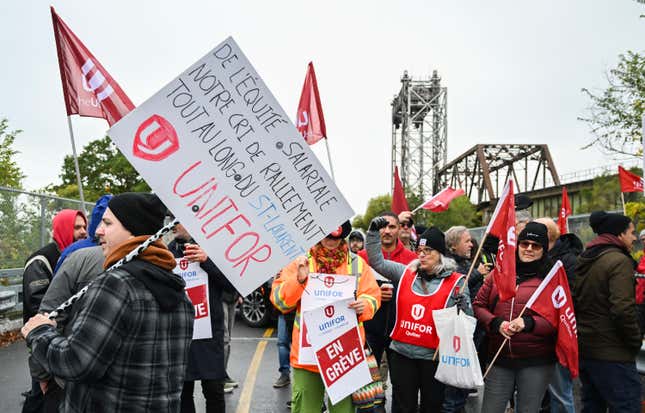 FILE - Striking St. Lawrence Seaway workers picket outside the St. Lambert Lock in St. Lambert, Quebec, Monday, Oct. 23, 2023. A deal was reached Sunday, Oct. 29, to end a week-long strike that had shut down a major shipping artery in the Great Lakes, halting the flow of grain and other goods from the U.S. and Canada. (Graham Hughes/The Canadian Press via AP)