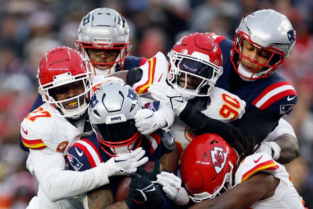 FOXBOROUGH, MASSACHUSETTS - DECEMBER 17: Chamarri Conner #27, Charles Omenihu #90, and Nick Bolton #32 of the Kansas City Chiefs tackle Ezekiel Elliott #15 of the New England Patriots during the fourth quarter at Gillette Stadium on December 17, 2023 in Foxborough, Massachusetts. (Photo by Sarah Stier/Getty Images)