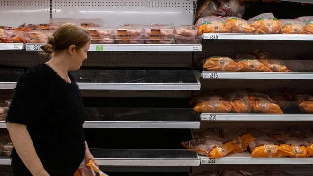 Woman looking at empty grocery store shelves