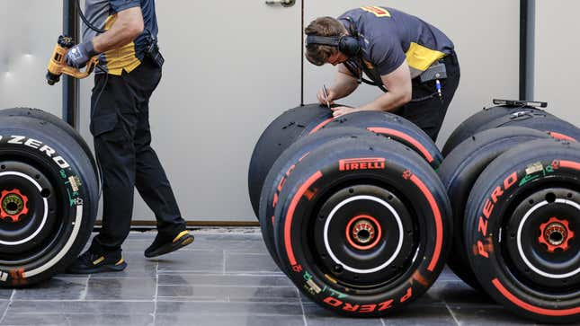 A photo of a McLaren engineer working on a set of tires. 