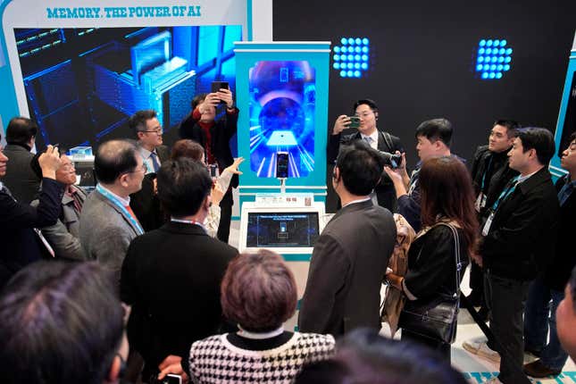 People crowd around an AI Fortune Teller at the SK booth during the CES tech show Wednesday, Jan. 10, 2024, in Las Vegas. (AP Photo/John Locher)