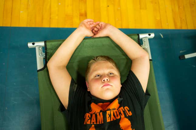 Zachary Stivers, 11, of Lost Creek, Kentucky, rests on a cot in the  Hazard Community &amp; Technical College, where survivors of the major  flooding in Eastern Kentucky are being taken for shelter on July 28,  2022 in Breathitt County, Kentucky. 