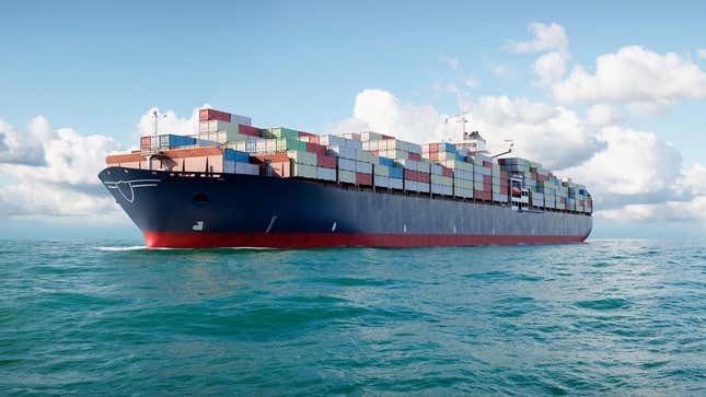A large cargo ship carrying containers is sailing at sea.