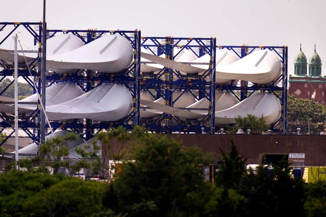 FILE - Giant wind turbine blades for the Vineyard Winds project are stacked on racks in the harbor, July 11, 2023, in New Bedford, Mass. Vineyard Wind, the wind farm under construction off the coast of Massachusetts, has begun delivering energy to the power grid from five of the planned 62 wind turbines now up and running, company and state officials said Thursday, Feb. 22, 2024. (AP Photo/Charles Krupa, File)