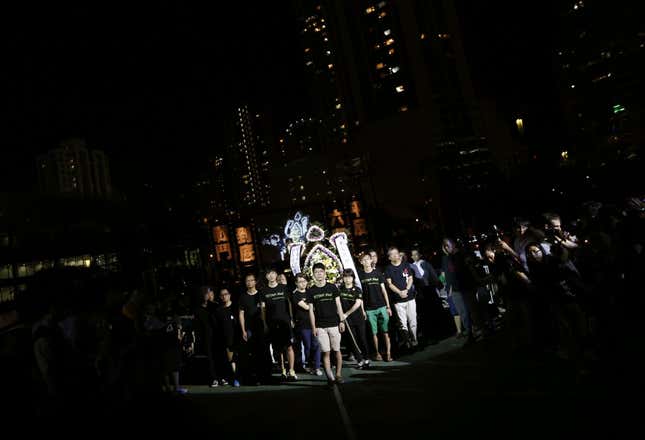 Student protesters walk with wreath during candlelight vigil at Hong Kong's Victoria Park to commemorate those killed during June 4th military crackdown on pro-democracy movement in Beijing