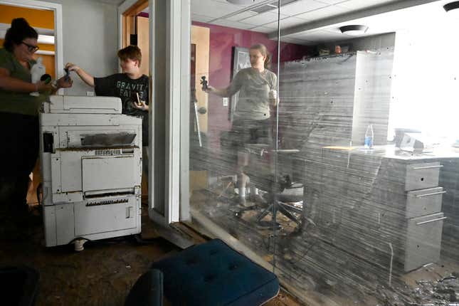 Employees of the Hindman Settlement School clean out the offices of the  school following flooding in Hindman, Ky., Friday, July 29, 2022.