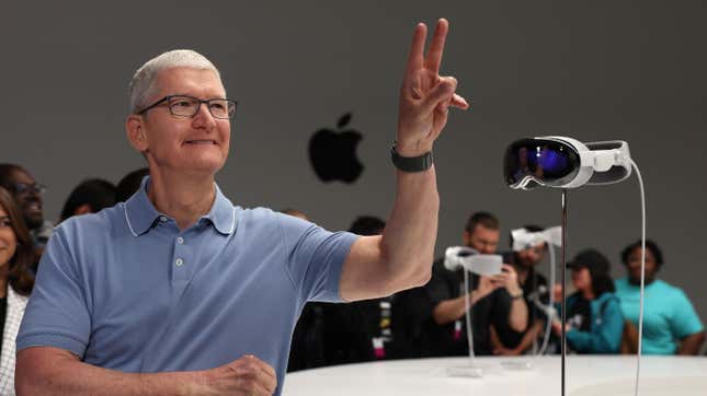 Apple CEO Tim Cook stands next to the new Apple Vision Pro headset is displayed during the Apple Worldwide Developers Conference on June 05, 2023 in Cupertino, California