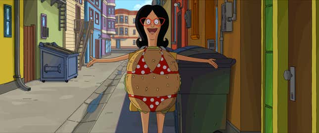 Linda stands in an empty alley while wearing a burger costume with red and white bikini over it.