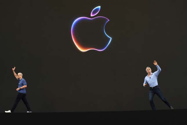 Tim Cook and Craig Federighi on opposite sides of the photo, both waving against a black backdrop with a colorfully-outlined Apple logo