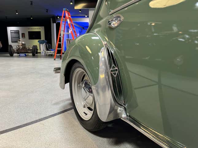 Rear wheel arch of a green 1954 Renault 4CV Berline