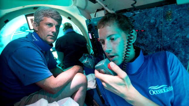 A photo of two people inside a submarine. 