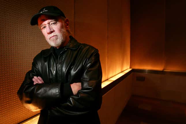 FILE - Actor and comedian George Carlin poses in a New York hotel March 19, 2004. Carlin&#39;s estate has filed a lawsuit against the media company behind a fake hourlong comedy special that purportedly uses artificial intelligence to recreate the late standup comic’s style and material. The lawsuit filed in federal court in Los Angeles on Thursday, Jan. 25, 2024, asks that a judge order the podcast outlet, Dudesy, to immediately take down the audio special, “George Carlin: I&#39;m Glad I&#39;m Dead,&quot; in which a synthesis of Carlin, who died in 2008, delivers commentary on current events. (AP Photo/Gregory Bull, File)