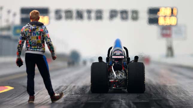 A photo of a drag racer at the start line of a drag strip. 