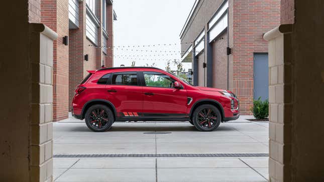 A photo of the side of Mitsubishi SUV parked on a street. 