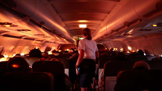 DALLAS, TX - NOVEMBER 24: A flight attendant walks through an airplane before the plane’s descent into the Dallas/Fort Worth International Airport on November 24, 2021 in Dallas, Texas.