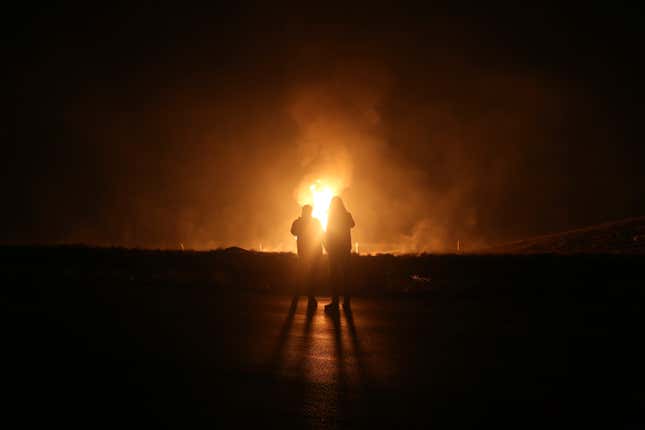 Two men look at flames after a natural gas pipeline explodes outside the city of Boroujen in the western Chaharmahal and Bakhtiari province, Iran, in early Wednesday, Feb. 14, 2024. Explosions struck a natural gas pipeline in Iran early Wednesday, with an official blaming the blasts on a &quot;sabotage and terrorist action&quot; in the country as tensions remain high in the Middle East amid Israel&#39;s war on Hamas in the Gaza Strip. (Reza Kamali Dehkordi/Fars News Agency via AP)