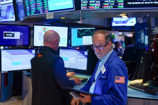 FILE = Traders work on the floor at the New York Stock Exchange in New York, Wednesday, July 26, 2023. Fees for mutual funds and exchange-traded funds fell to a record low last year, according to Morningstar. Fund investors paid about $37 in fees for every $10,000 invested, down from $40 in 2021. Altogether, that saved them a collective $9.8 billion. (AP Photo/Seth Wenig, File)