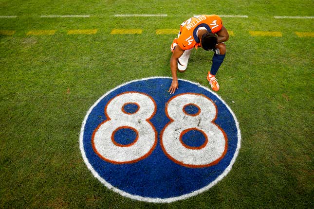 Courtland Sutton #14 of the Denver Broncos kneels and takes a moment in front of the #88 tribute logo to the late former Denver Broncos player Demaryius Thomas after the game against the Detroit Lions at Empower Field At Mile High on December 12, 2021 in Denver, Colorado.