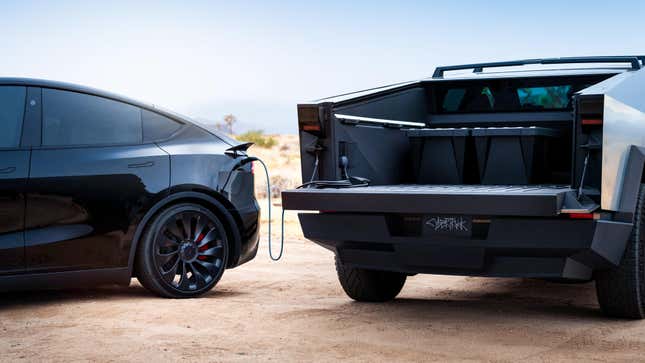 the rear of a cybertruck open while a Model Y is plugged into it 