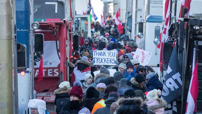 Supporters arrive at Parliament Hill for the Freedom Truck Convoy to protest against Covid-19 vaccine mandates and restrictions in Ottawa, Canada, on January 29, 2022. - Hundreds of truckers drove their giant rigs into the Canadian capital Ottawa on Saturday as part of a self-titled “Freedom Convoy” to protest vaccine mandates required to cross the US border. 