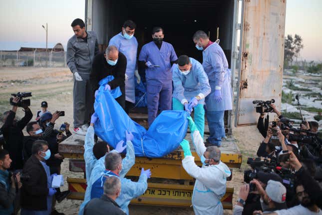 Medics unload the bodies of Palestinians killed in the north of the Gaza Strip and turned over by the Israeli military in Rafah, Tuesday, Dec. 26, 2023. (AP Photo/Hatem Ali)