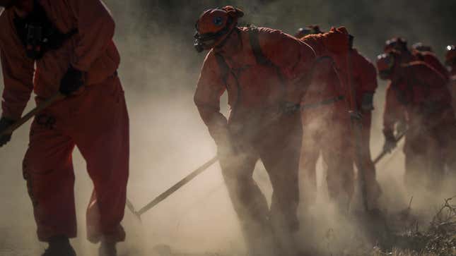 Incarcerated firefighters from Oak Glen Conservation Camp clear vegetation that could fuel a wildfire near Yucaipa, California, on September 28, 2017.