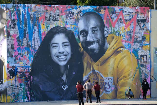 People stop to take pictures in front of the new mural by French artist Mr. Brainwash picturing Kobe Bryant and his daughter Gigi in Los Angeles on January 31, 2020. 