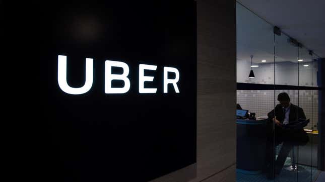 Uber signage is seen as an employee sits in the entrance of the ride-hailing giant’s office in Hong Kong on March 10, 2017.