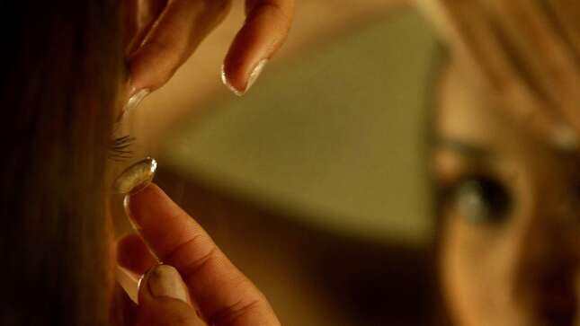 Model Amruta Patki puts in her contact lenses as she prepares for a show on the penultimate day of the Lakme Fashion Week in Mumbai, India, Friday, March 30, 2007.