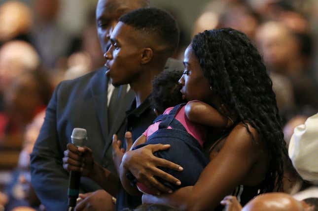 Dravon Ames, holding microphone, speaks to Phoenix Police Chief Jeri Williams and Phoenix Mayor Kate Gallego, as his fiancee, Iesha Harper, right, holds 1-year-old daughter London, at a community meeting, in Phoenix on Tuesday, June 18, 2019