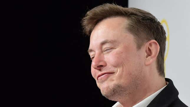 A photo of Elon Musk smiling on stage. 