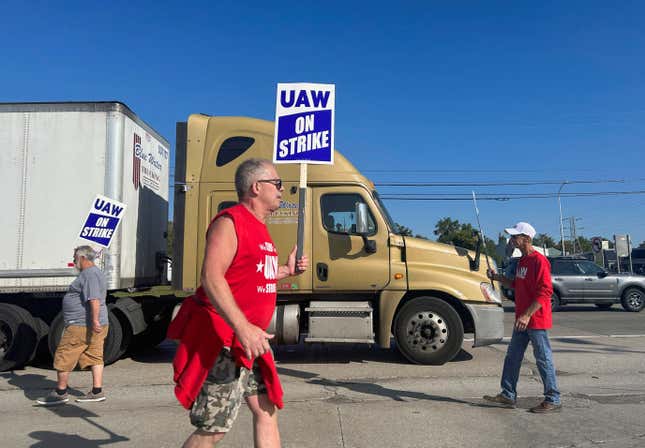 United Auto Workers Local 900 members hold signs while on strike outside the Michigan Ford Assembly Plant.