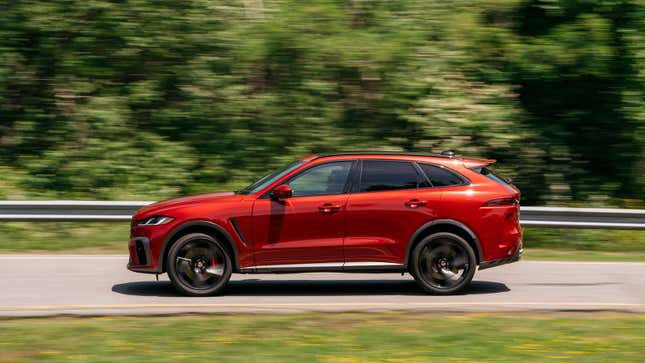 A photo of a red Jaguar F-Pace SUV driving on a highway. 