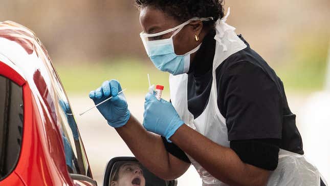 A nurse conducting covid-19 testing at a drive-in testing site in the UK.