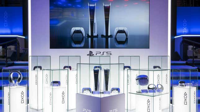 PS5s sit in glass cases on a stage. 