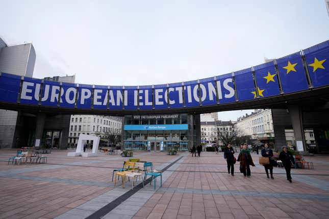 FILE - People walk under a banner advertising the European elections outside the European Parliament in Brussels, on Jan. 24, 2024. TikTok is taking measures to combat misinformation about the upcoming European Union elections including setting up fact-checking hubs inside the app, the video-sharing platform said Wednesday Feb. 14, 2024. (AP Photo/Virginia Mayo, File)