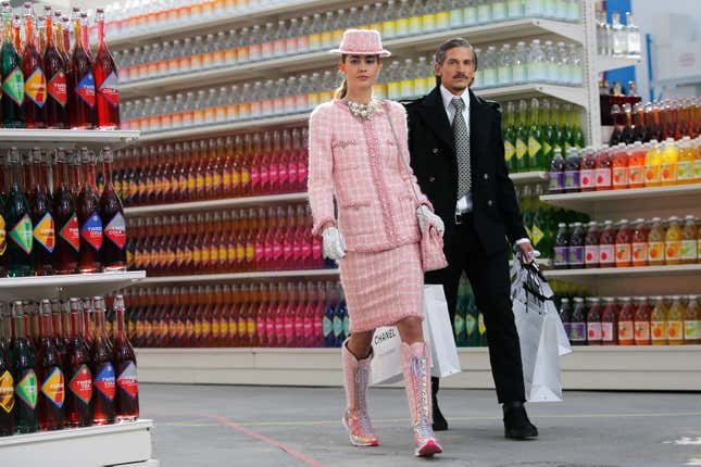 Models present creations by German designer Karl Lagerfeld as part of his Fall/Winter 2014-2015 women's ready-to-wear collection for French fashion house Chanel at the Grand Palais transformed into a "Chanel Shopping Center" during Paris Fashion Week March 4, 2014.