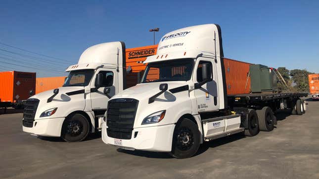 A pair of Freightliner eCascadia semi trucks