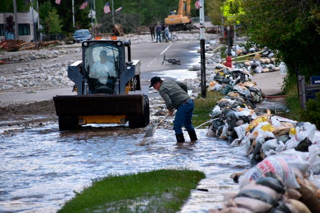 Residents of Red Lodge, Montana, are seen clearing mud, water and debris  from the small city’s main street on Tuesday, June 14, 2022, after  flood waters courses through a residential area with hundreds of homes.