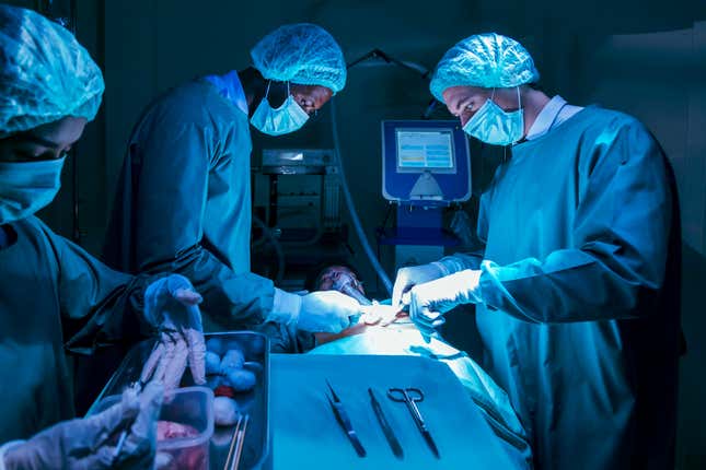 Team of surgeon doctors are performing heart surgery operation for patient